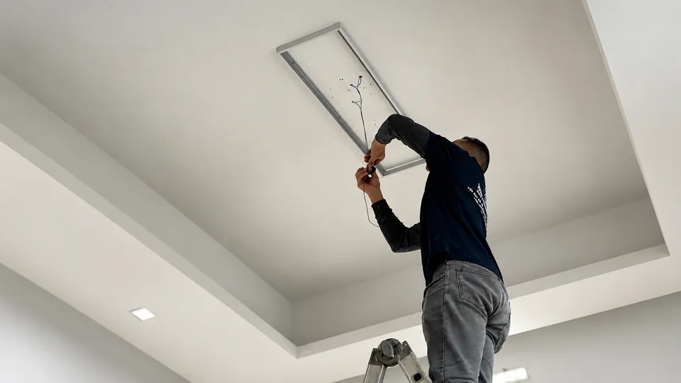 WildJobs technician installing a ceiling light